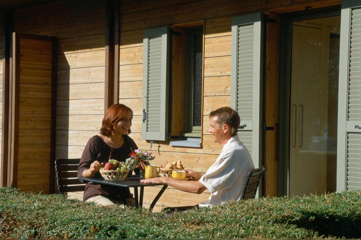 un homme et une femme assis à une table dans l'établissement Résidence Les Vignes, à Jonzac 27 autres photos