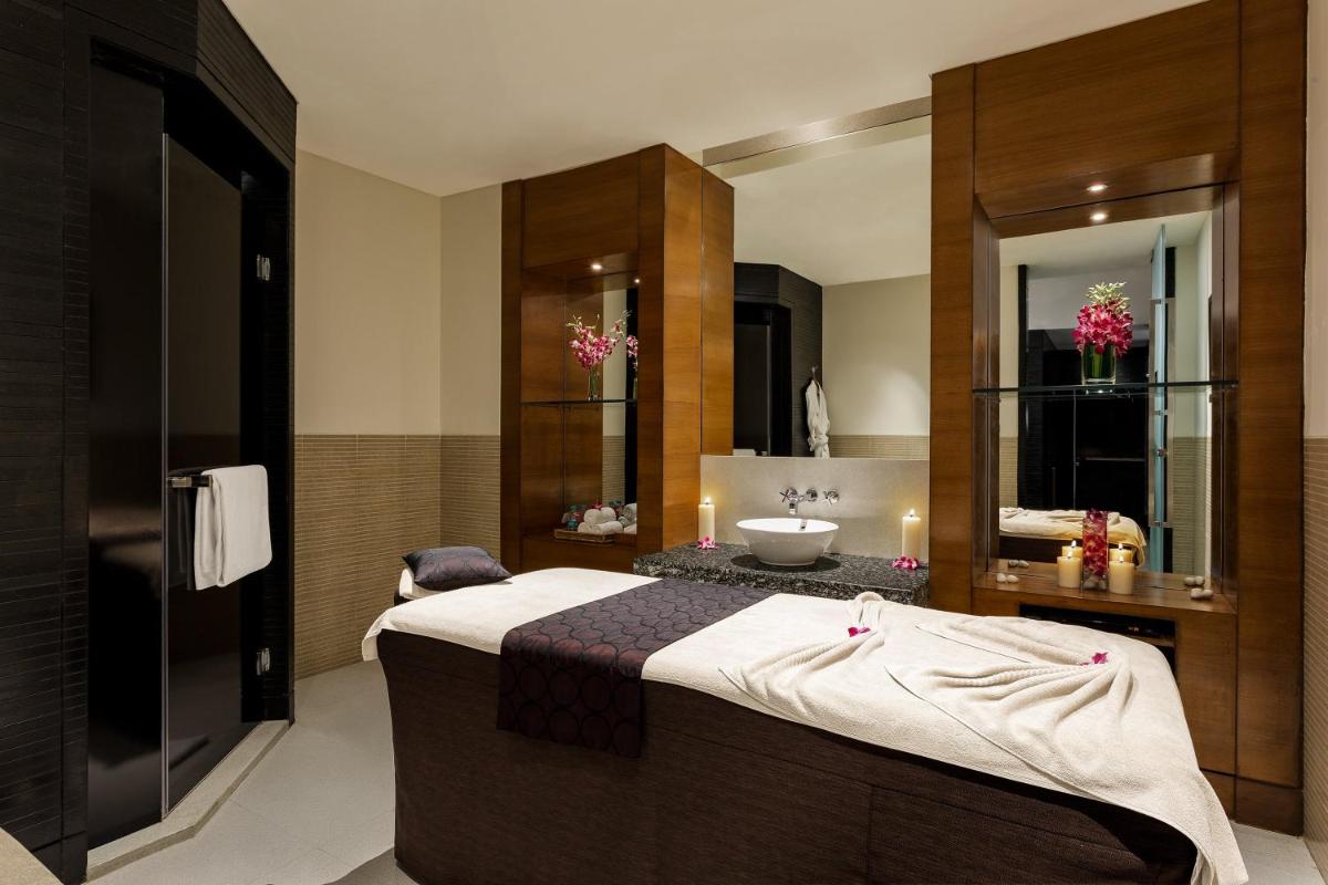 a bathroom with a bed and a sink and a mirror at Crowne Plaza Today Gurugram by IHG in Gurgaon