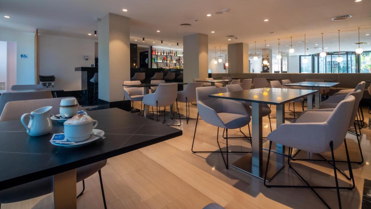 Un restaurante con mesas y sillas y un bar. en Isla Mallorca & Spa, en Palma de Mallorca