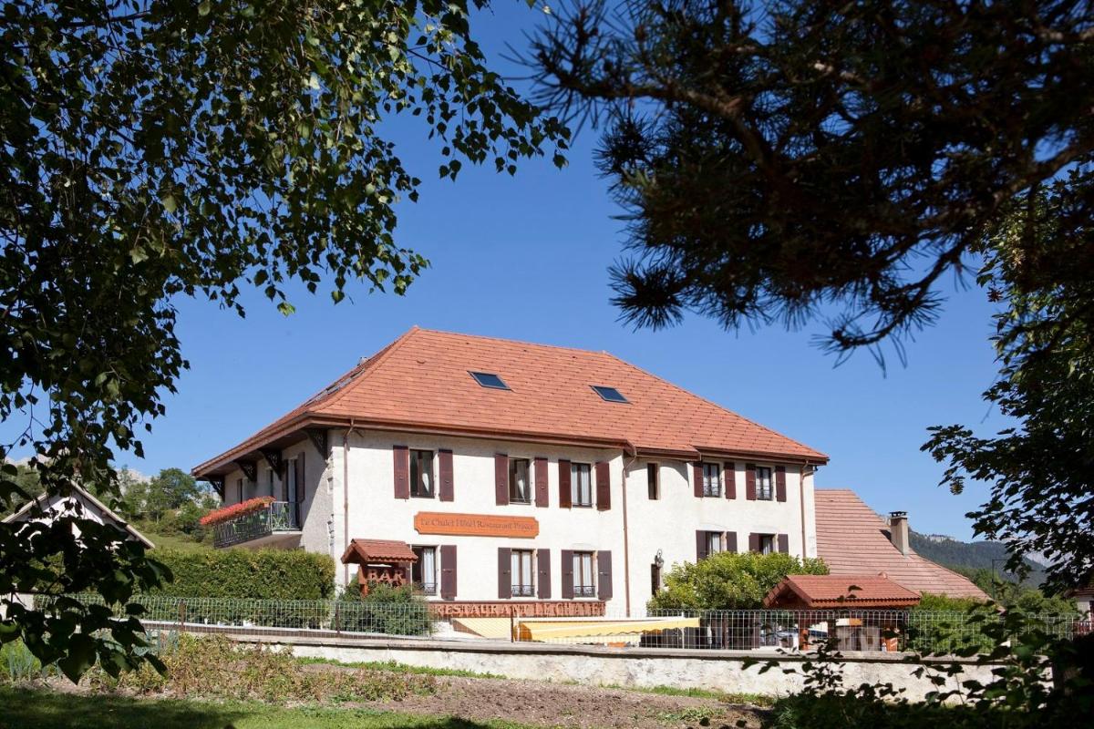 un grand bâtiment blanc avec un toit rouge dans l'établissement Hotel le Chalet, à Gresse-en-Vercors