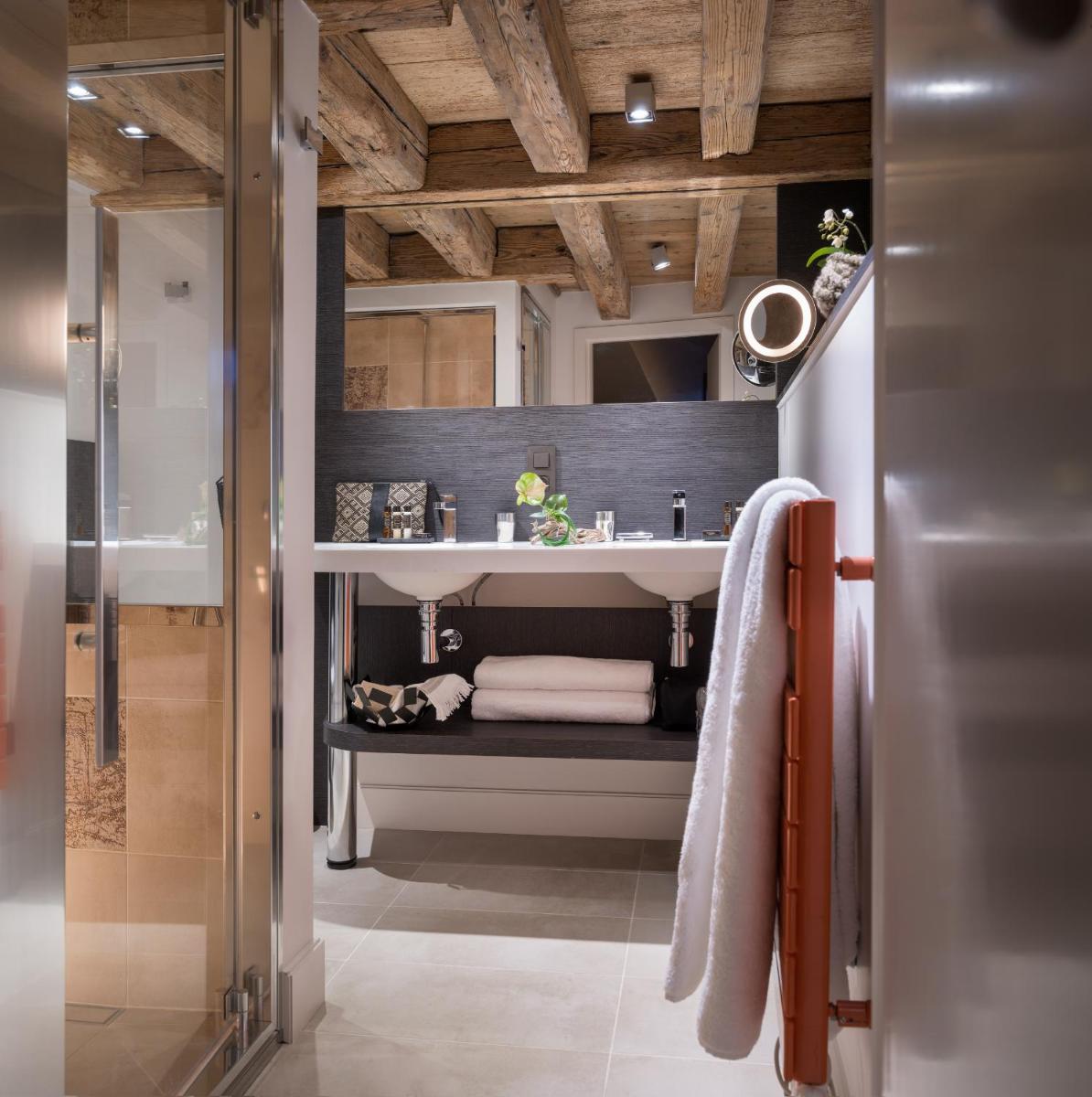 une salle de bain avec un lavabo et un miroir dans l'établissement Les Loges Annecy Vieille Ville, à Annecy
