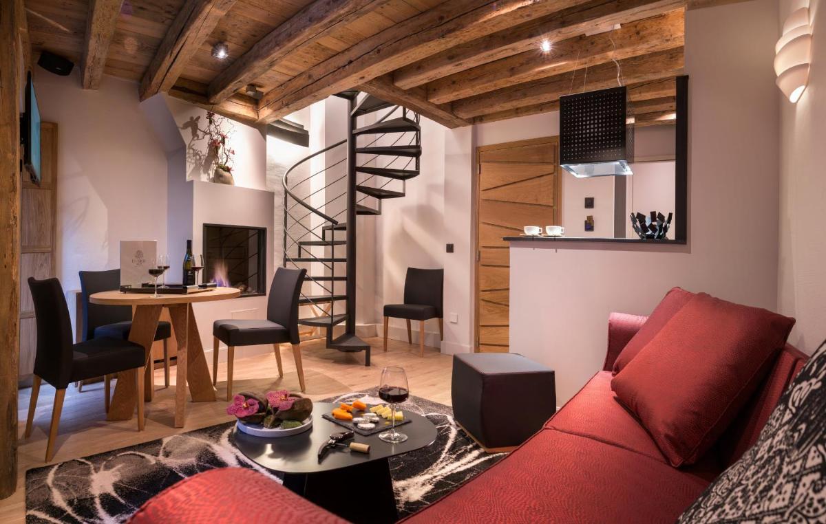 un salon avec un canapé rouge et une table dans l'établissement Les Loges Annecy Vieille Ville, à Annecy 10 autres photos