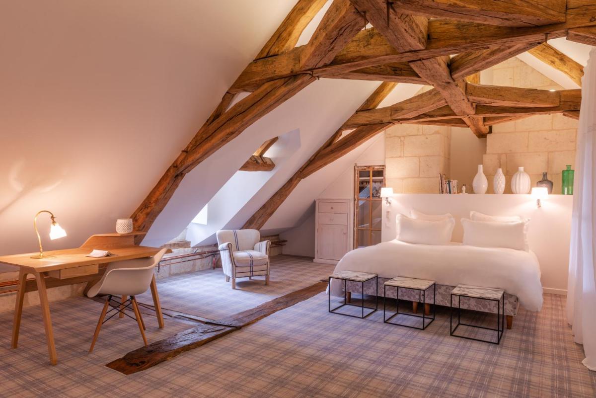 - une chambre avec un grand lit blanc et un bureau en bois dans l'établissement Le Domaine de Mestré, The Originals Relais, à Fontevraud-l'Abbaye