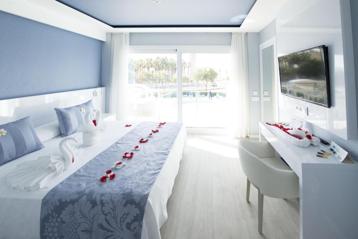 un dormitorio con una larga mesa con rosas rojas. en Masd Mediterraneo Hotel Apartamentos Spa, en Castelldefels 114 fotos más
