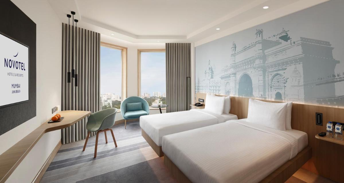a hotel room with a bed and a desk at Novotel Mumbai Juhu Beach in Mumbai