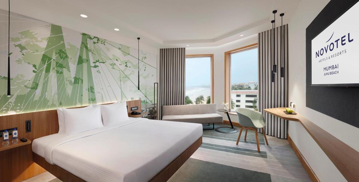 a hotel room with a bed and a television at Novotel Mumbai Juhu Beach in Mumbai
