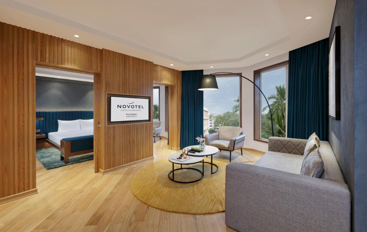 a hotel room with a couch and a bed at Novotel Mumbai Juhu Beach in Mumbai