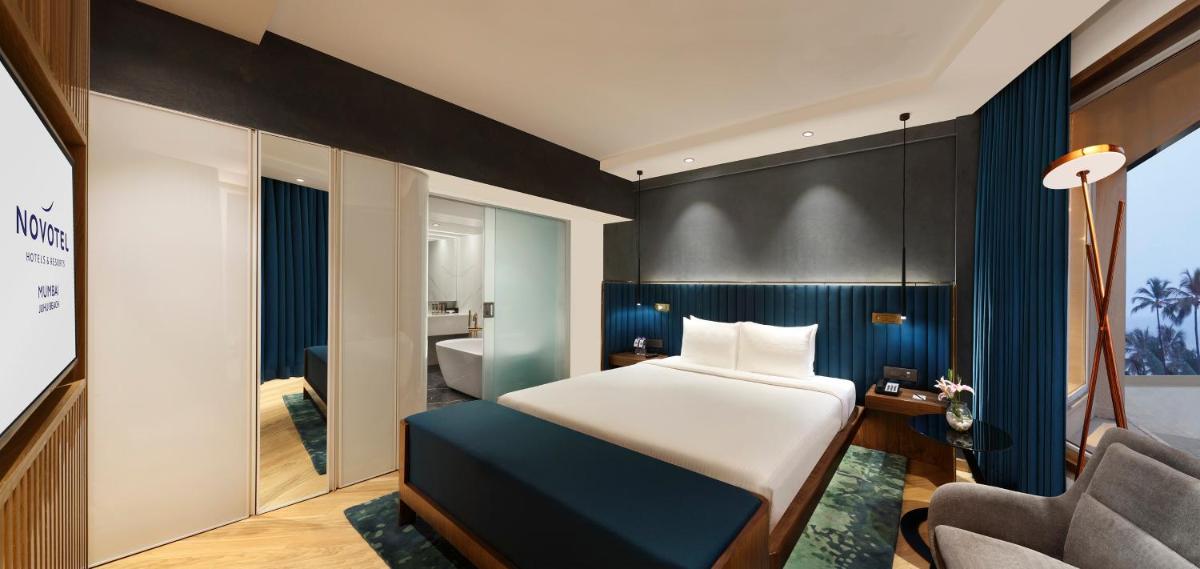 a hotel room with a bed and a chair at Novotel Mumbai Juhu Beach in Mumbai