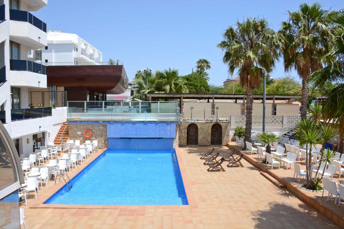 Una piscina con tumbonas y un hotel. en Don Angel & SPA & Padel- Adults Recommended, en Santa Susanna Una piscina con tumbonas y un hotel. en Don Angel & SPA & Padel- Adults Recommended, en Santa Susanna
