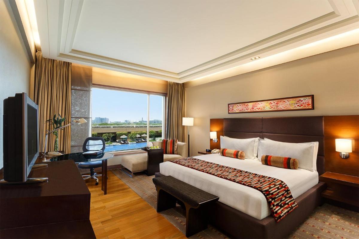 a hotel room with a large bed and a television at Crowne Plaza Today Gurugram by IHG in Gurgaon