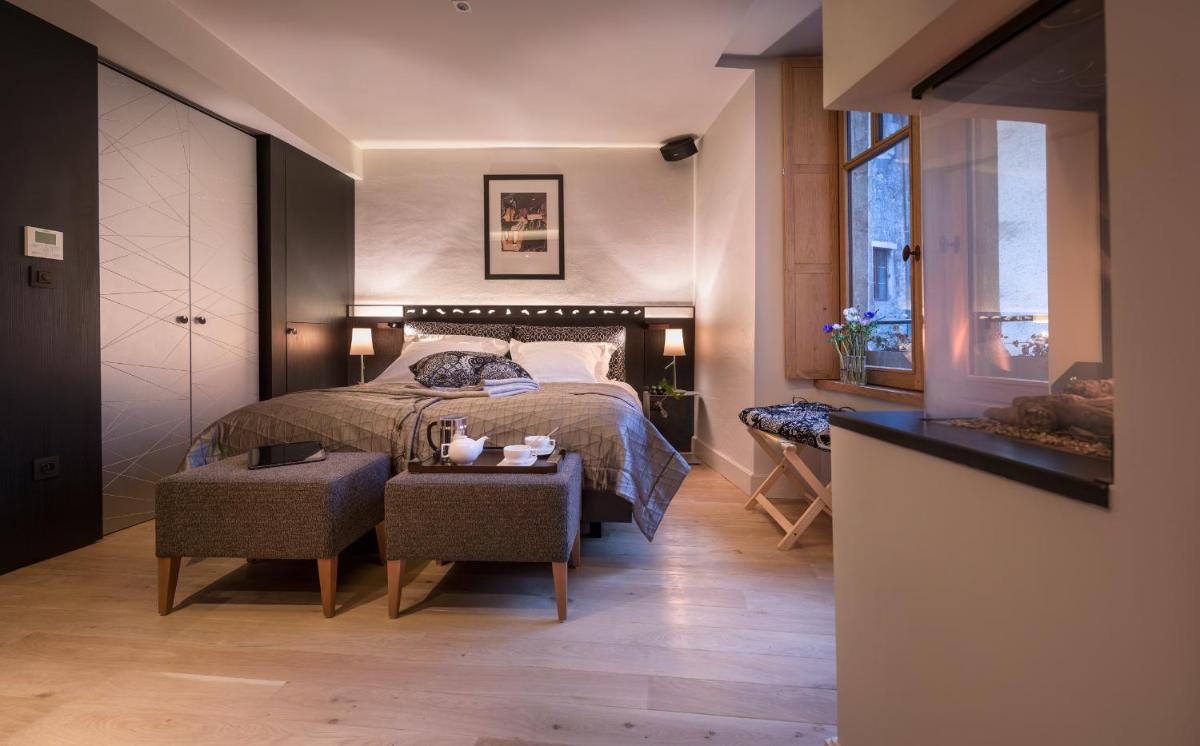 une chambre avec un lit et une table avec des chaises dans l'établissement Les Loges Annecy Vieille Ville, à Annecy