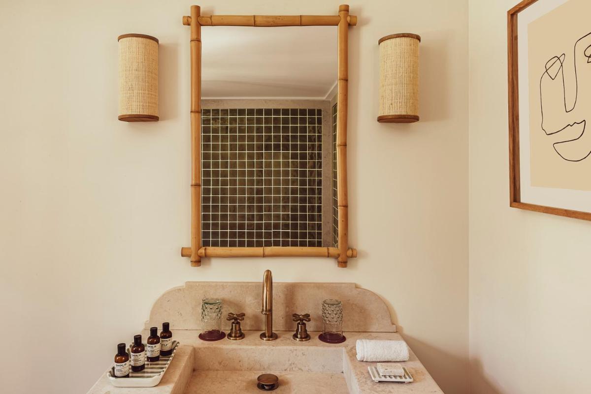 une salle de bain avec un lavabo et un miroir dans l'établissement Hotel Lou Pinet, à Saint-Tropez une salle de bain avec un lavabo et un miroir dans l'établissement Hotel Lou Pinet, à Saint-Tropez