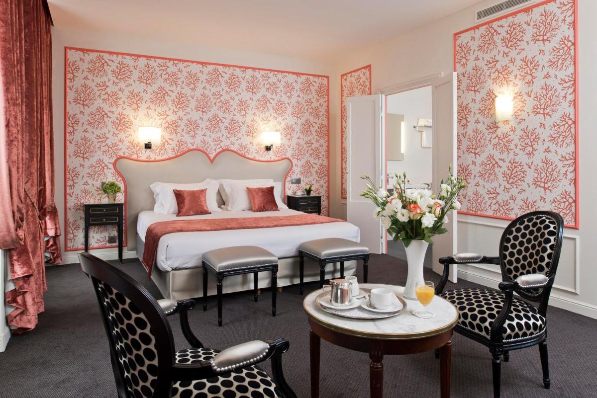 une chambre avec un lit, une table et des chaises dans l'établissement Hôtel Saint-Pétersbourg Opéra & Spa, à Paris