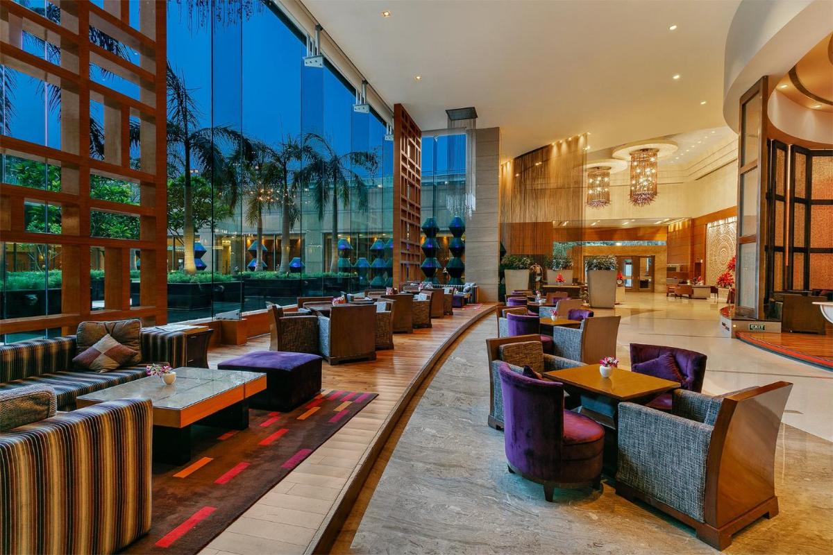 a restaurant with tables and chairs in a building at Crowne Plaza Today Gurugram by IHG in Gurgaon