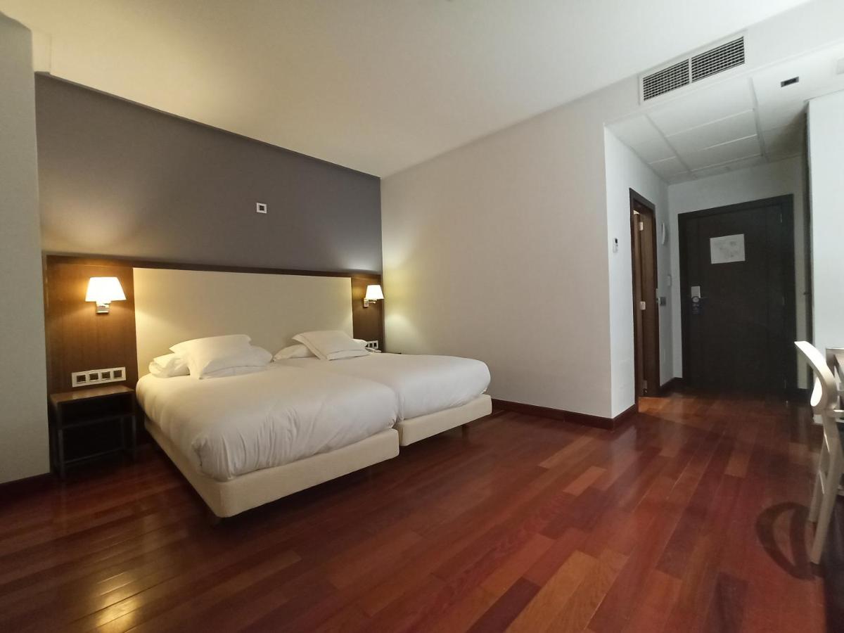 1 dormitorio con 1 cama blanca grande y suelo de madera en ARVA Spa París, en León