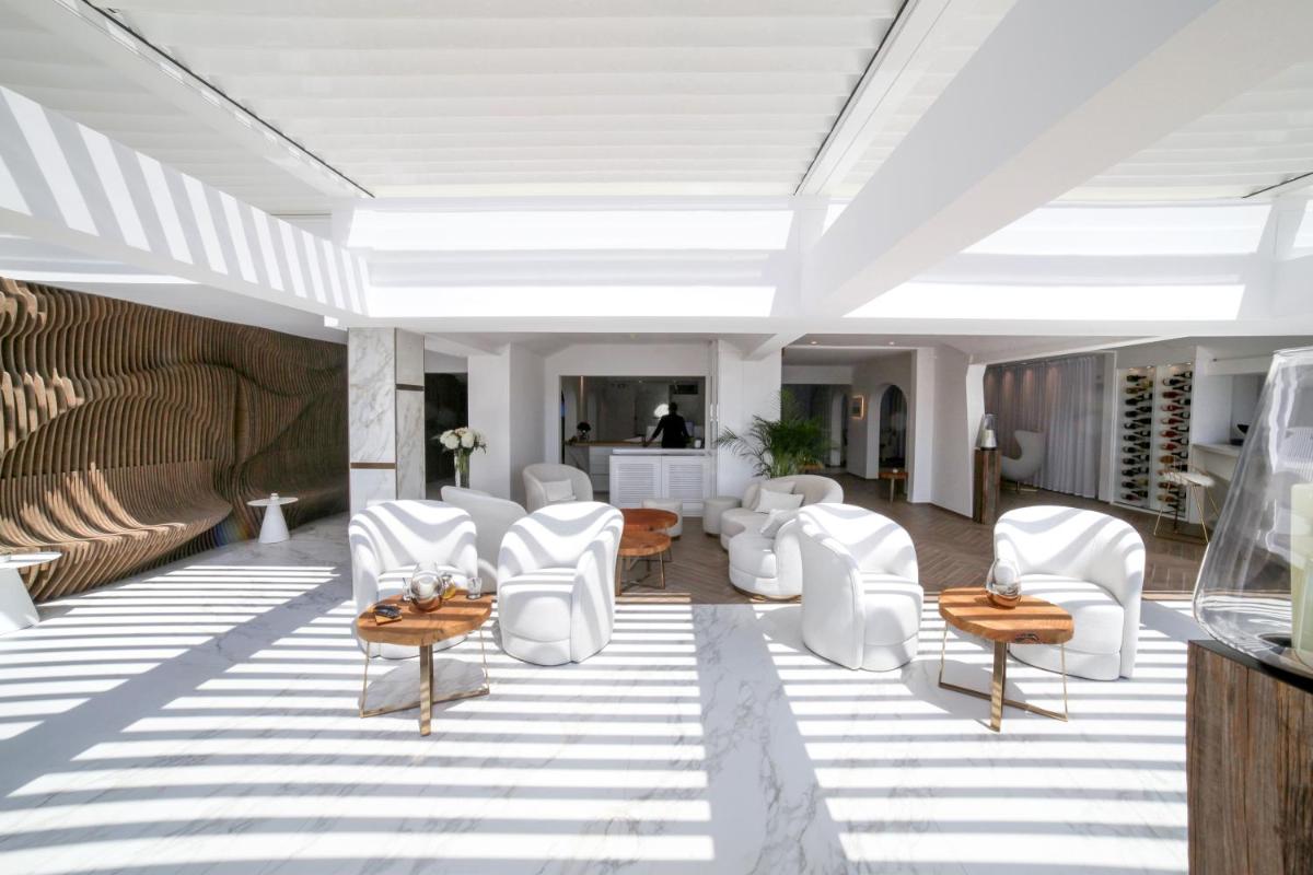 une salle avec des chaises et des tables blanches dans l'établissement Hôtel Marinca & Spa, à Olmeto