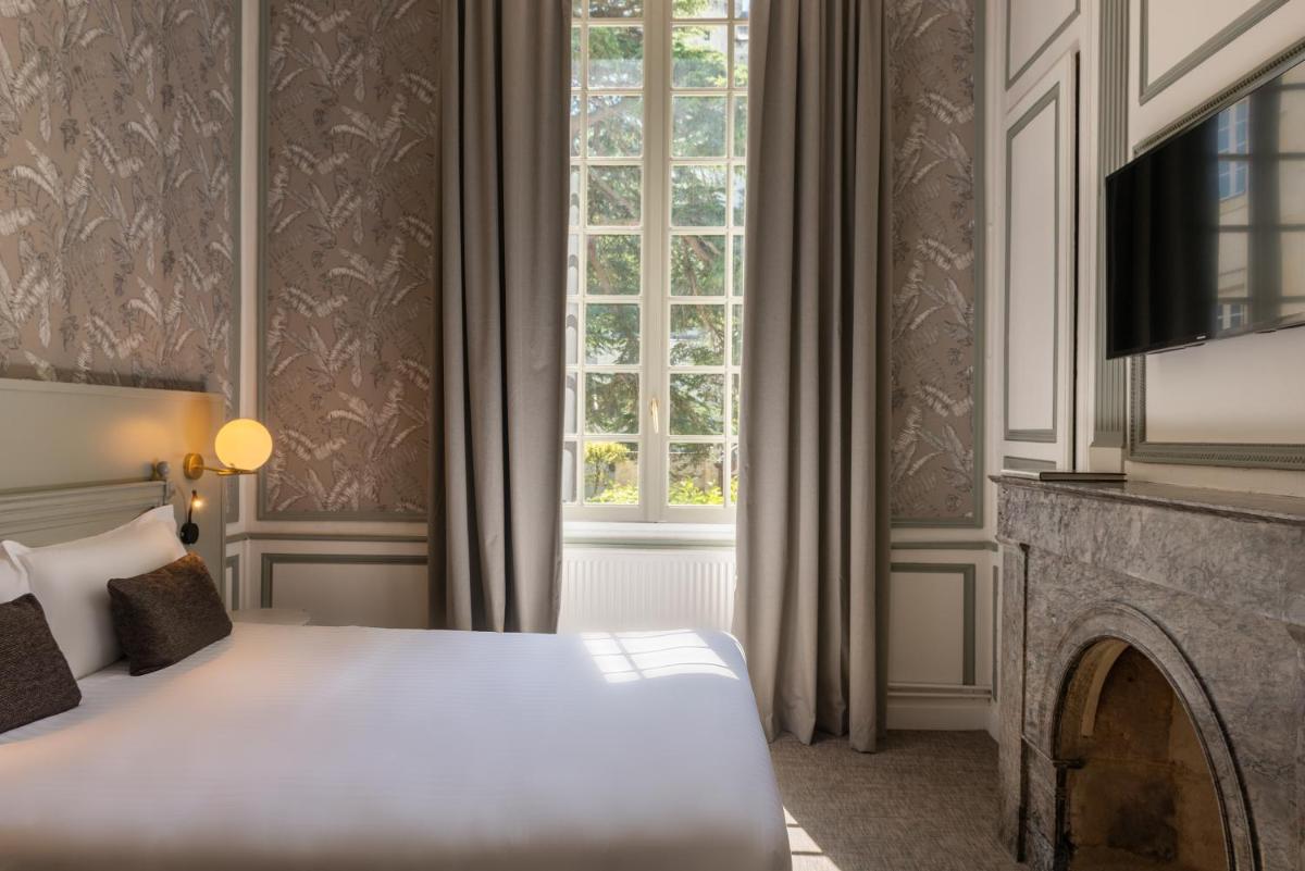 Un ou plusieurs lits dans un hébergement de l'établissement Hôtel Anne d'Anjou, The Originals Collection