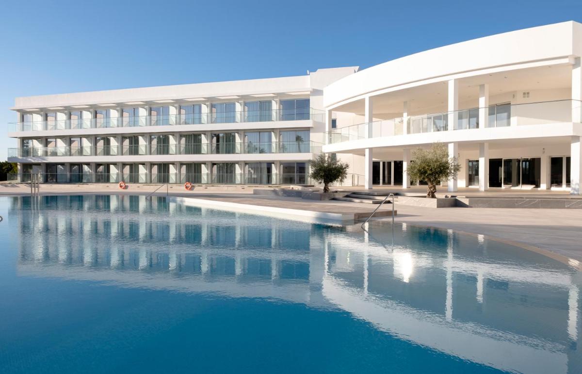 un edificio con piscina en frente de un edificio en Gran Sagitario, en Ciutadella