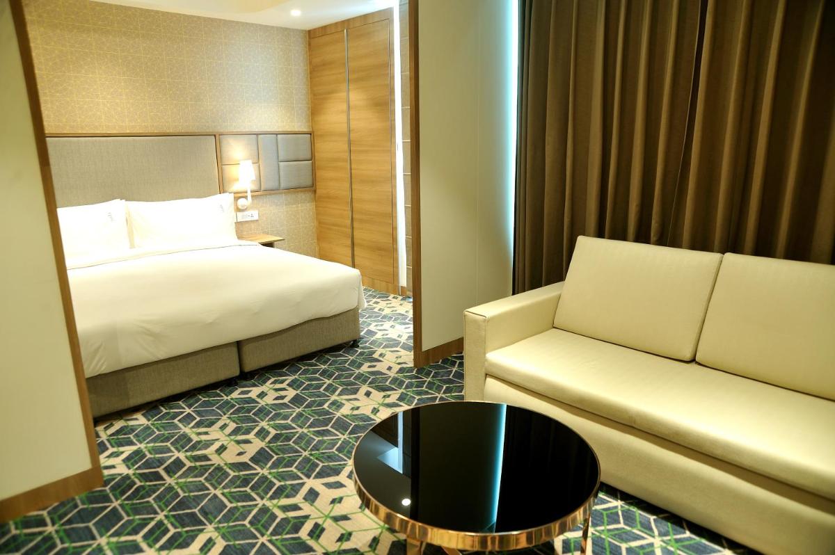 a hotel room with a bed and a couch at Holiday Inn Gurugram Sector 90 by IHG in Gurgaon
