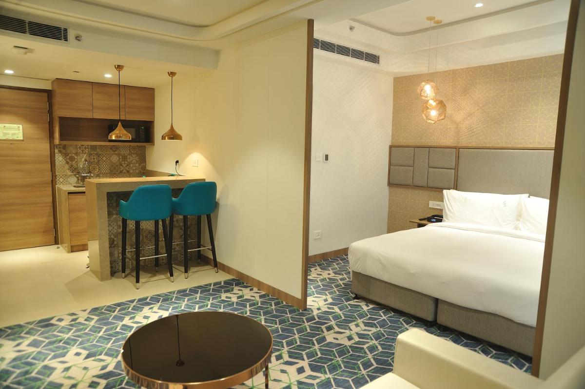 a hotel room with a bed and a kitchen at Holiday Inn Gurugram Sector 90 by IHG in Gurgaon