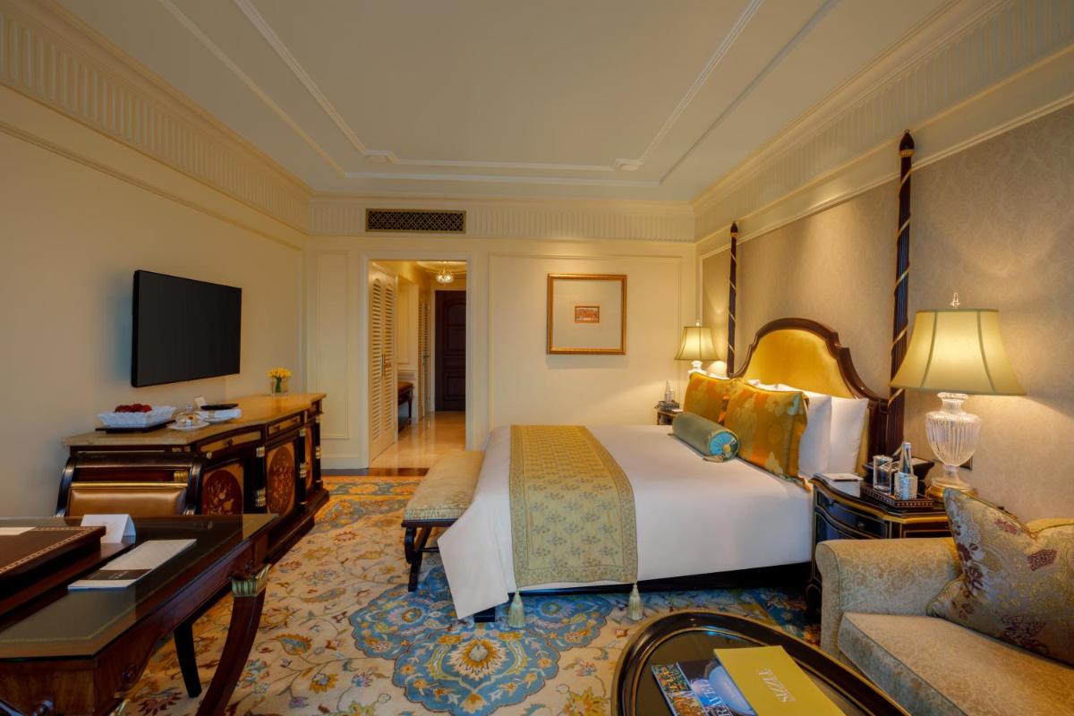 a hotel room with a bed and a desk at The Leela Palace New Delhi in New Delhi a hotel room with a bed and a desk at The Leela Palace New Delhi in New Delhi