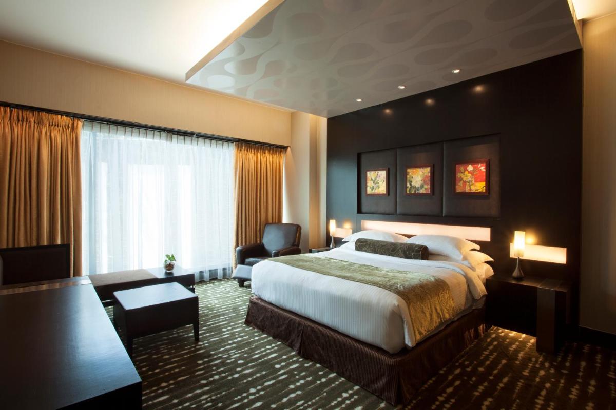 a hotel room with a bed and a chair at The Oterra in Bengaluru