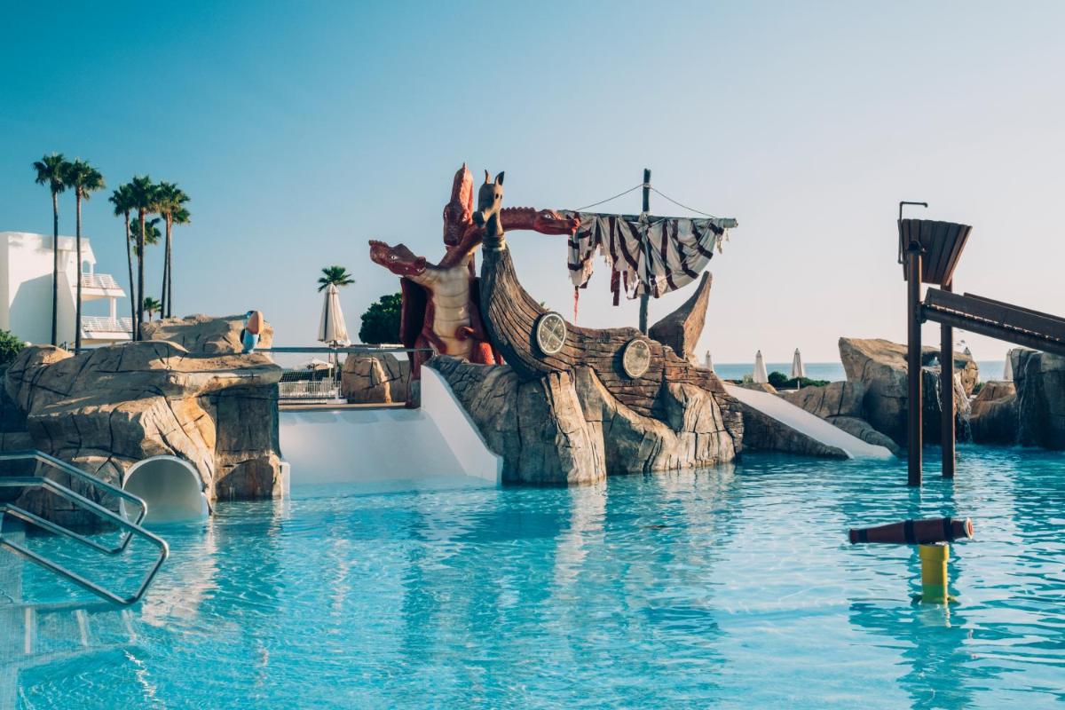 un tobogán de agua en una piscina de un complejo turístico en Iberostar Waves Royal Andalus, en Chiclana de la Frontera