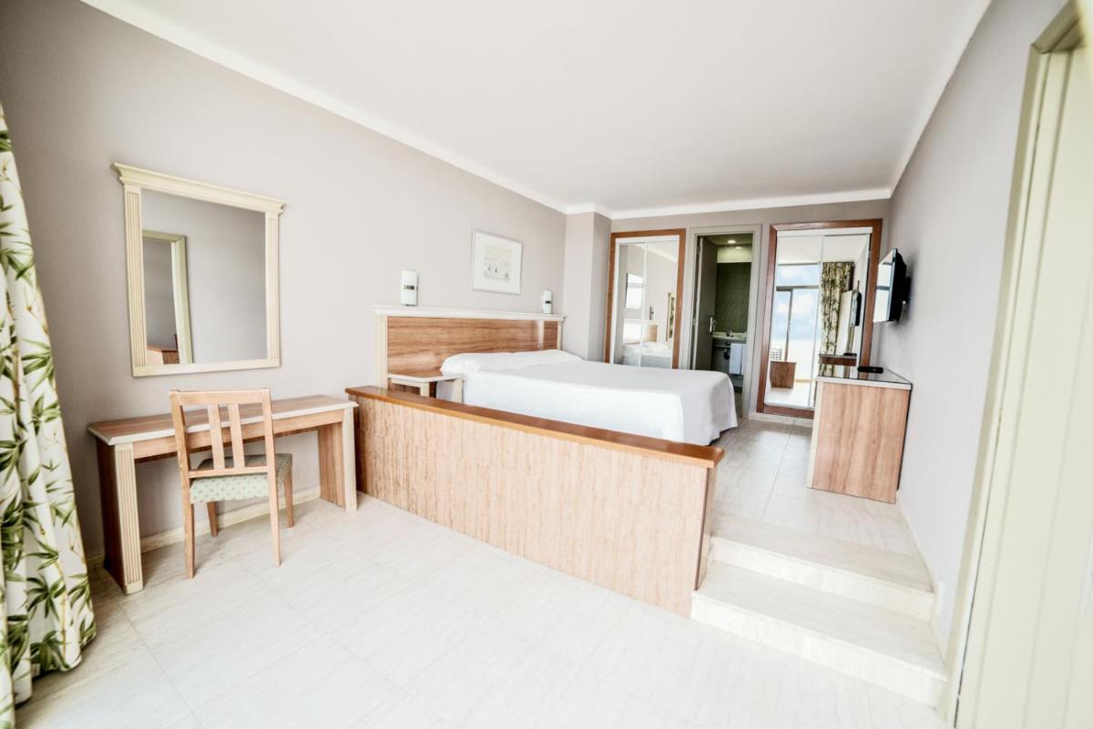 Una habitación de hotel con una cama, un escritorio y una silla. en Hotel Beatriz Playa & Spa, en Puerto del Carmen