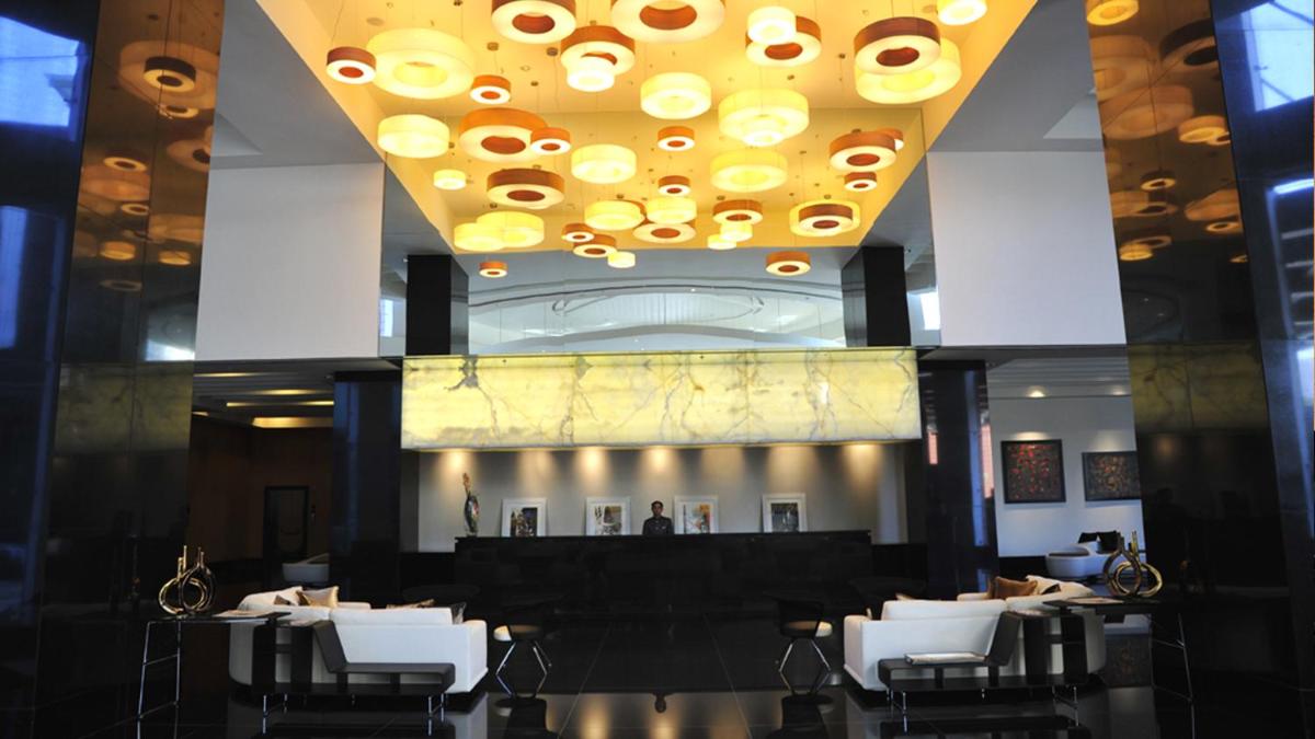 a dining room with white tables and a large ceiling at The Oterra in Bengaluru