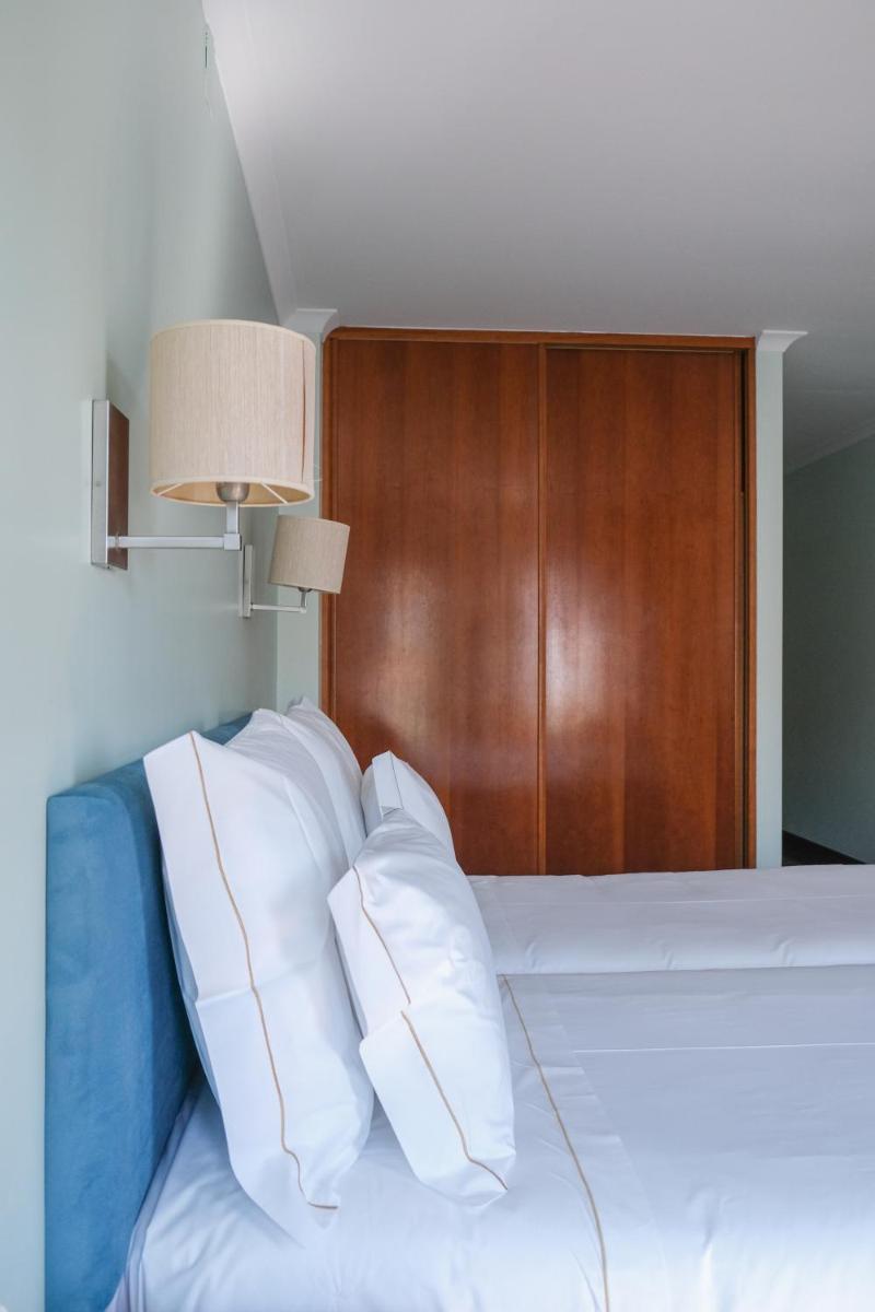 Uma cama ou camas num quarto em Hotel Vouga