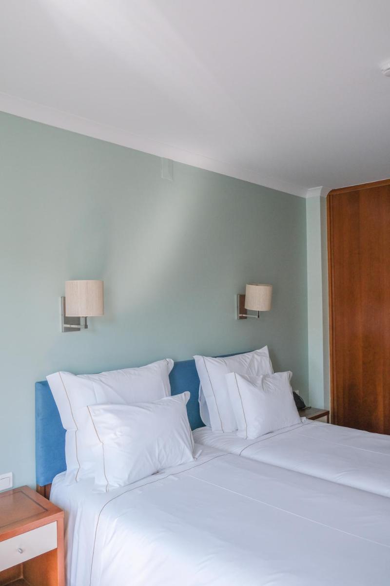 Uma cama ou camas num quarto em Hotel Vouga