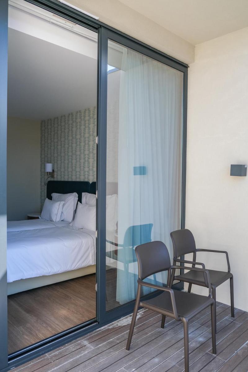 Uma cama ou camas num quarto em Hotel Vouga