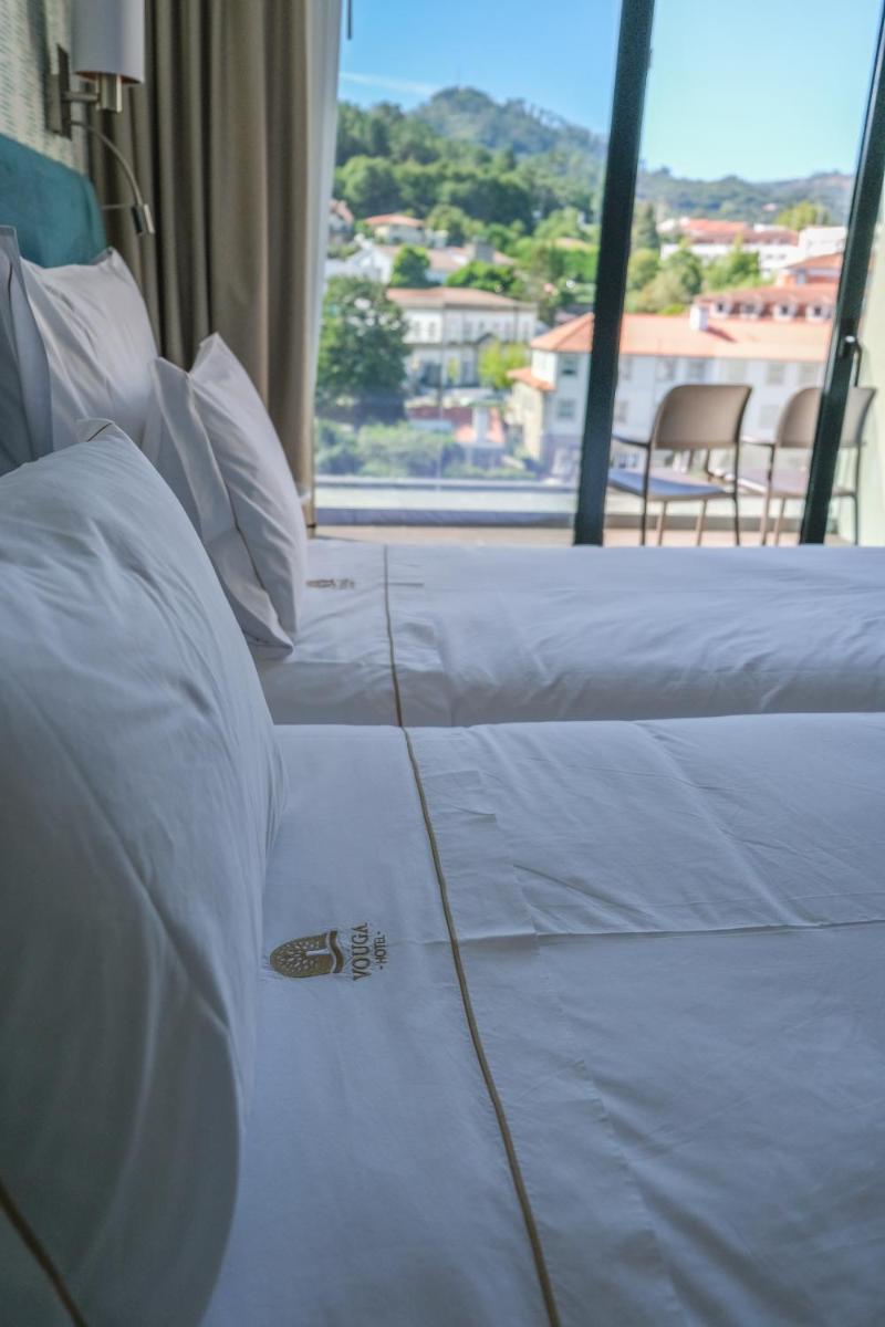 Uma cama ou camas num quarto em Hotel Vouga