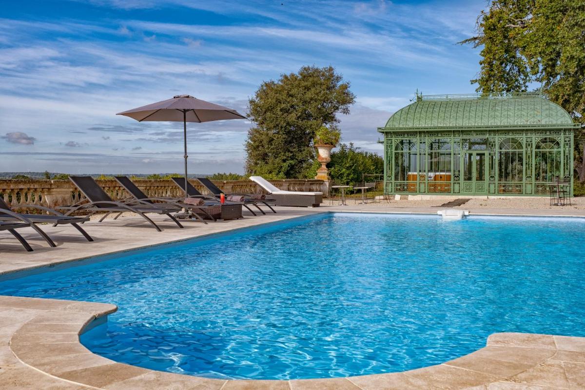 une piscine avec des chaises et un gazebo dans l'établissement Château de Tressé, à Pouancé une piscine avec des chaises et un gazebo dans l'établissement Château de Tressé, à Pouancé