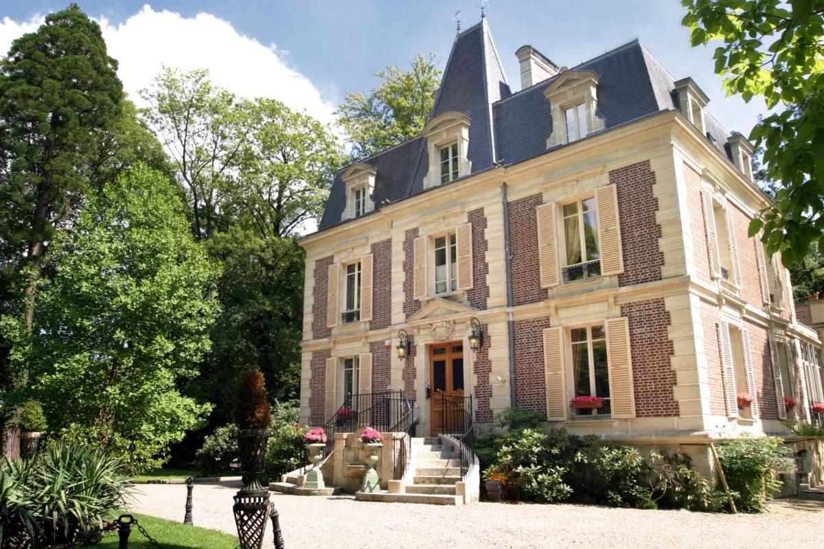 une grande maison en briques avec un toit dans l'établissement Les Jardins d'Epicure, à Bray-et-Lû