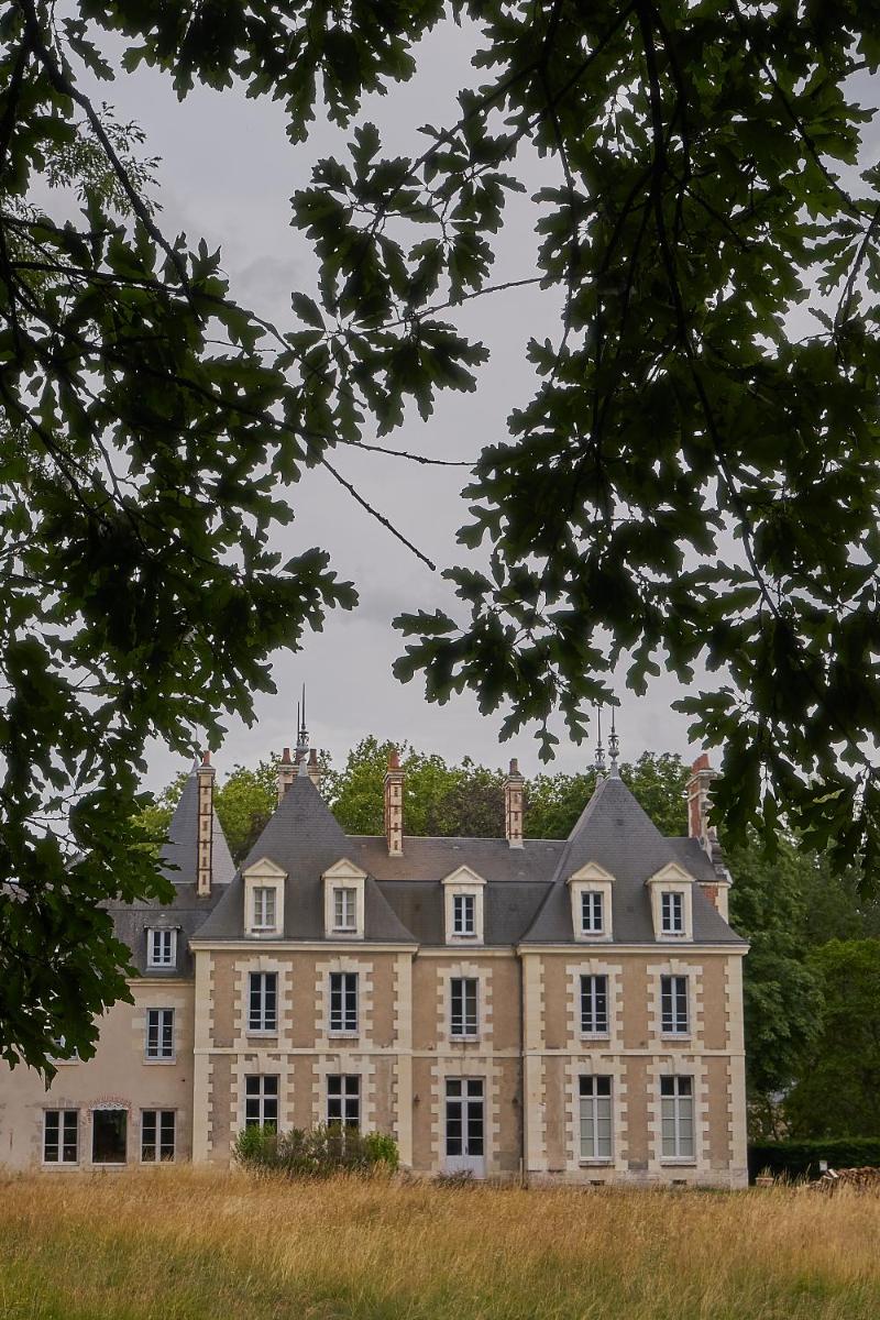 une grande maison en pierre avec deux cheminées dans l'établissement Les Sources de Cheverny, à Cheverny