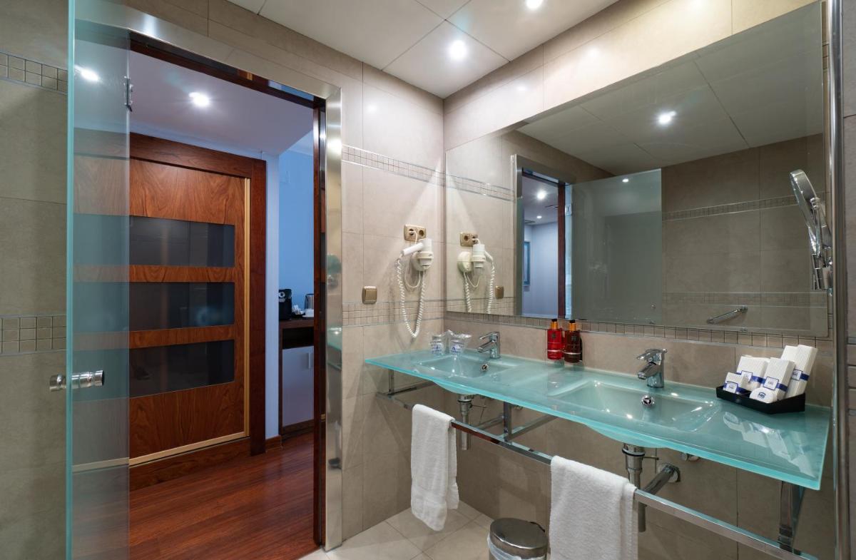 un baño con lavabo y espejo en Hotel MS Maestranza Málaga, en Málaga