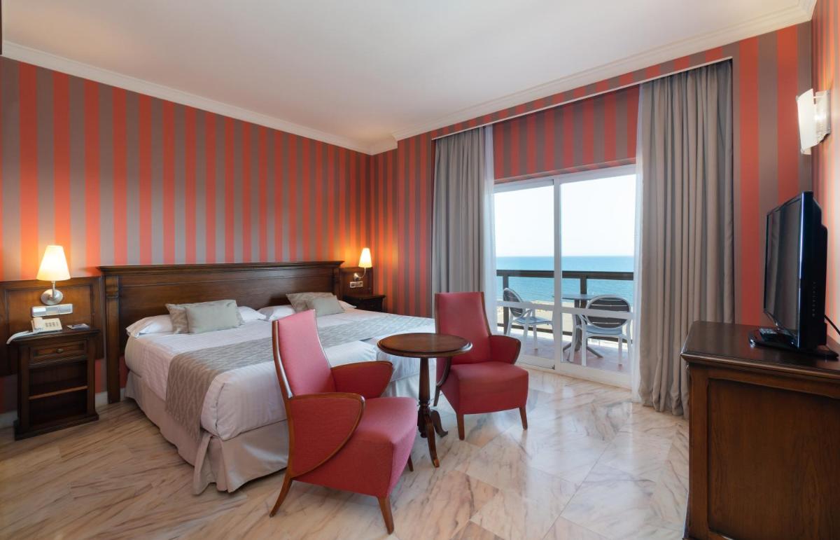 una habitación de hotel con una cama y un balcón en MS Amaragua, en Torremolinos 76 fotos más