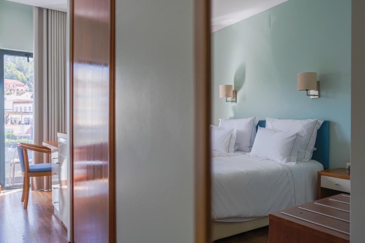 Uma cama ou camas num quarto em Hotel Vouga