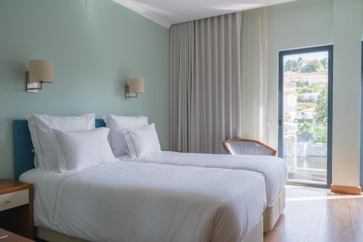 Uma cama ou camas num quarto em Hotel Vouga