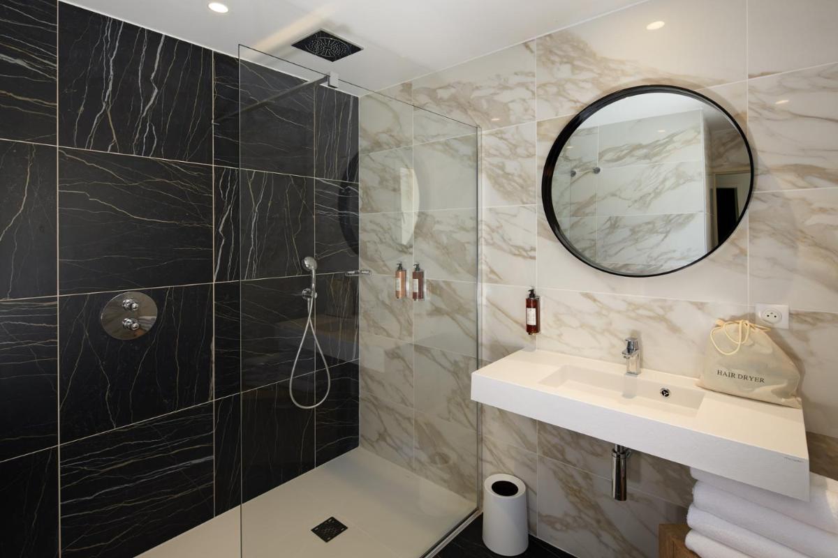une salle de bain avec un lavabo et un miroir dans l'établissement Les Nomades Beaune, à Beaune