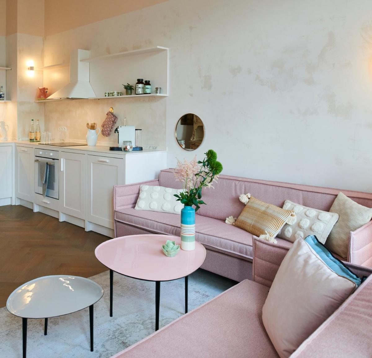 ein Wohnzimmer mit einem rosa Sofa und einem Tisch in der Unterkunft Cora Apartments in Leipzig