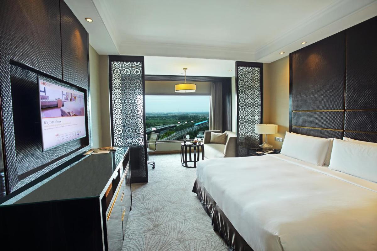 a hotel room with a bed and a flat screen tv at Crowne Plaza New Delhi Mayur Vihar Noida by IHG in New Delhi