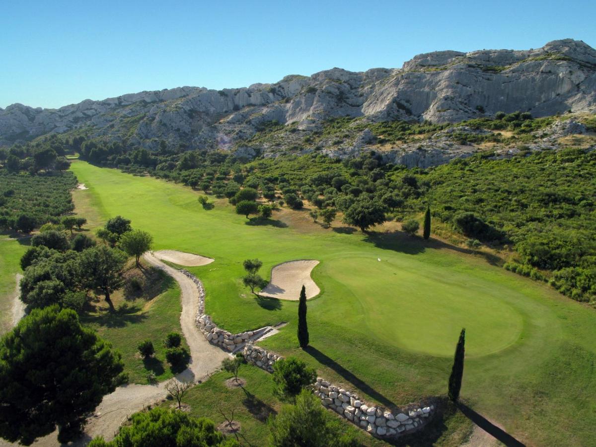 - une vue aérienne sur un parcours de golf avec des montagnes en arrière-plan dans l'établissement Bdesign & Spa, à Paradou
