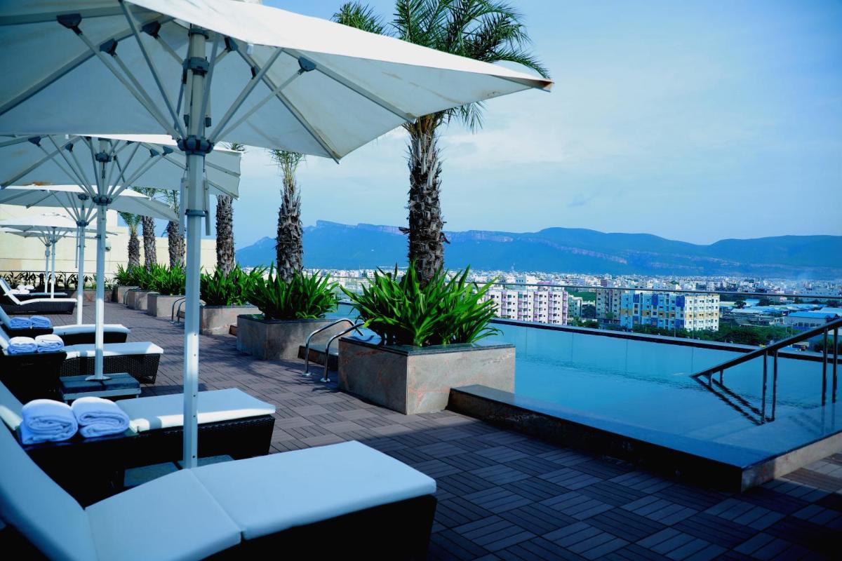 a pool with tables and umbrellas on a building at Taj Tirupati in Tirupati