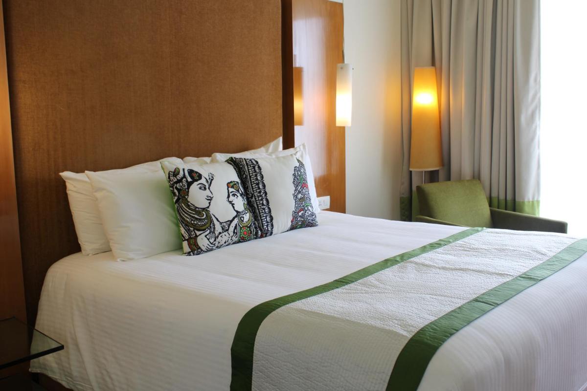 a hotel room with a large bed with pillows at The Park Chennai in Chennai a hotel room with a large bed with pillows at The Park Chennai in Chennai