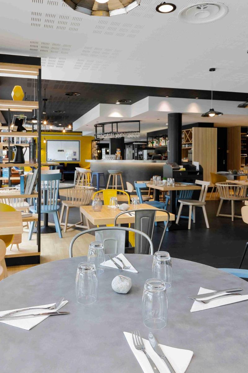 une salle à manger avec une table avec des couverts dessus dans l'établissement Campanile Roissy - Aéroport CDG - Le Mesnil Amelot, au Mesnil-Amelot