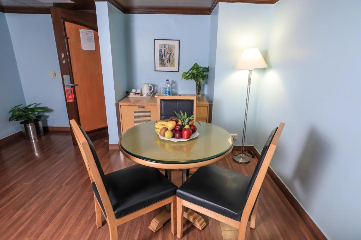 a dining room with a table and chairs with a bowl of fruit at The Piccadily in Lucknow
