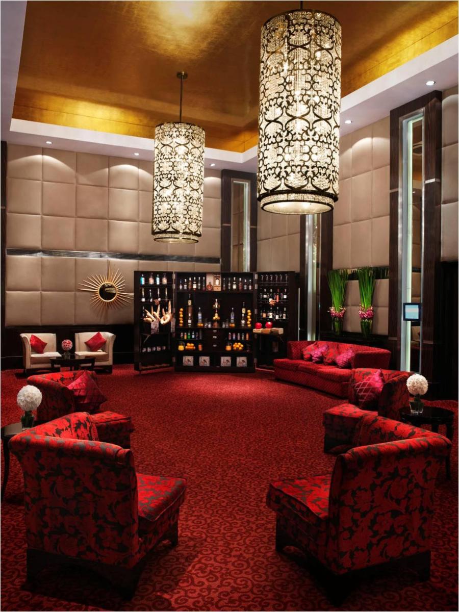 a lobby with red furniture and chandeliers at Sofitel Mumbai BKC in Mumbai
