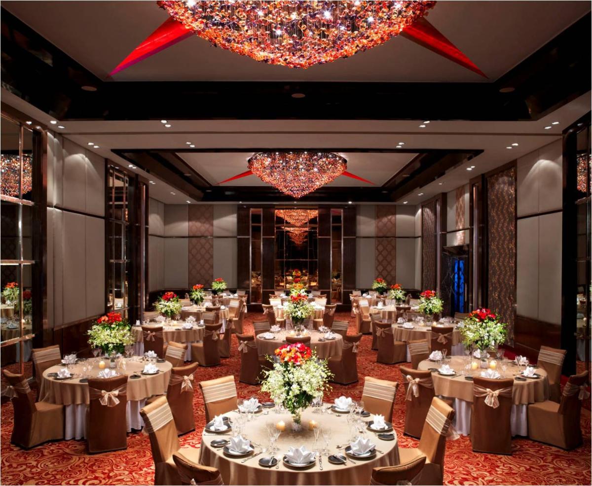 a large banquet room with tables and chairs and chandeliers at Sofitel Mumbai BKC in Mumbai